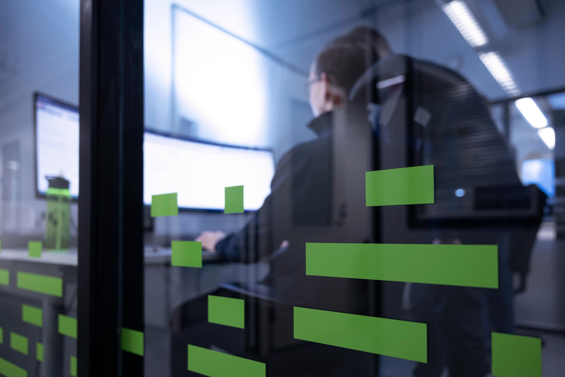 man-working-at-his-desk-pictured-through-glass