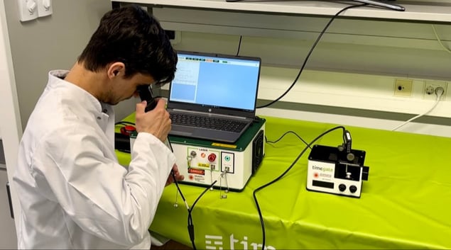 Man checking probe ends with a fiber microscope to ensure they are clean.