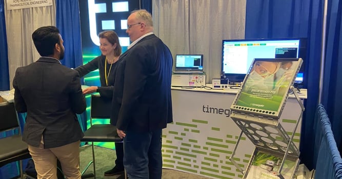 People talking at IFPAC event booth.